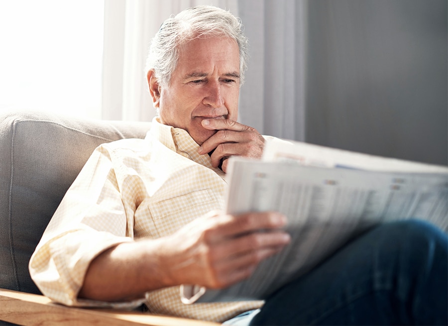 Shot of an elderly man reading a newspaper during a relaxing day at home